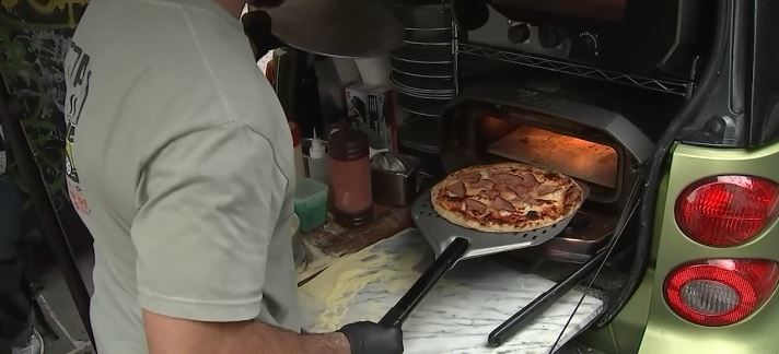 A small Smart car parked at 54th Street and 10th Avenue is turning heads - and stopping pedestrians in their tracks - thanks to the unmistakable aroma of fresh, stone-fired pizza coming from its open trunk.