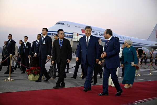 Chinese President Xi Jinping, third from right, is welcomed by Egyptian President Abdel-Fattah el-Sissi, second from right, followed by their wives Peng Liyuan, covered, and Entissar Amer, right, at Cairo International Airport in Cairo, Egypt, Tuesday, Sept. 1, 2026. (Khaled Desouki/Pool Photo via AP)