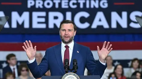 AFP via Getty Images J D Vance addressing a rally in Michigan