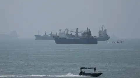 Reuters Large ships in the Strait of Hormuz are visible near the beach of Bandar Abbas.